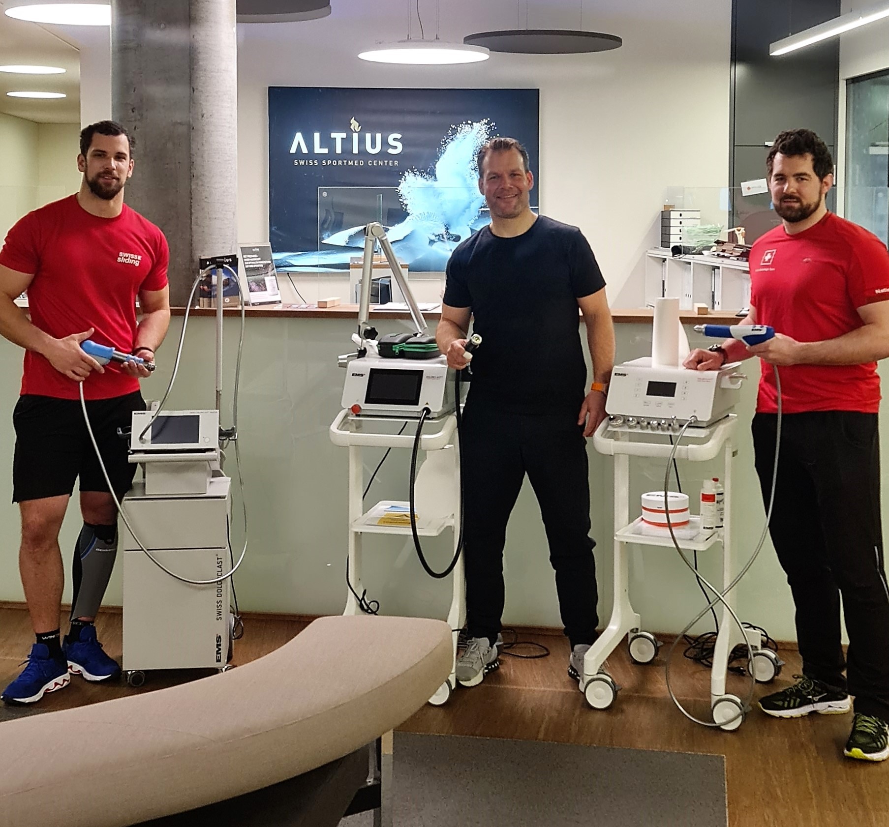 Felix Zimmermann, Simon Friedli und Sandro Michel mit den Geräten der Guided DolorClast Therapy
